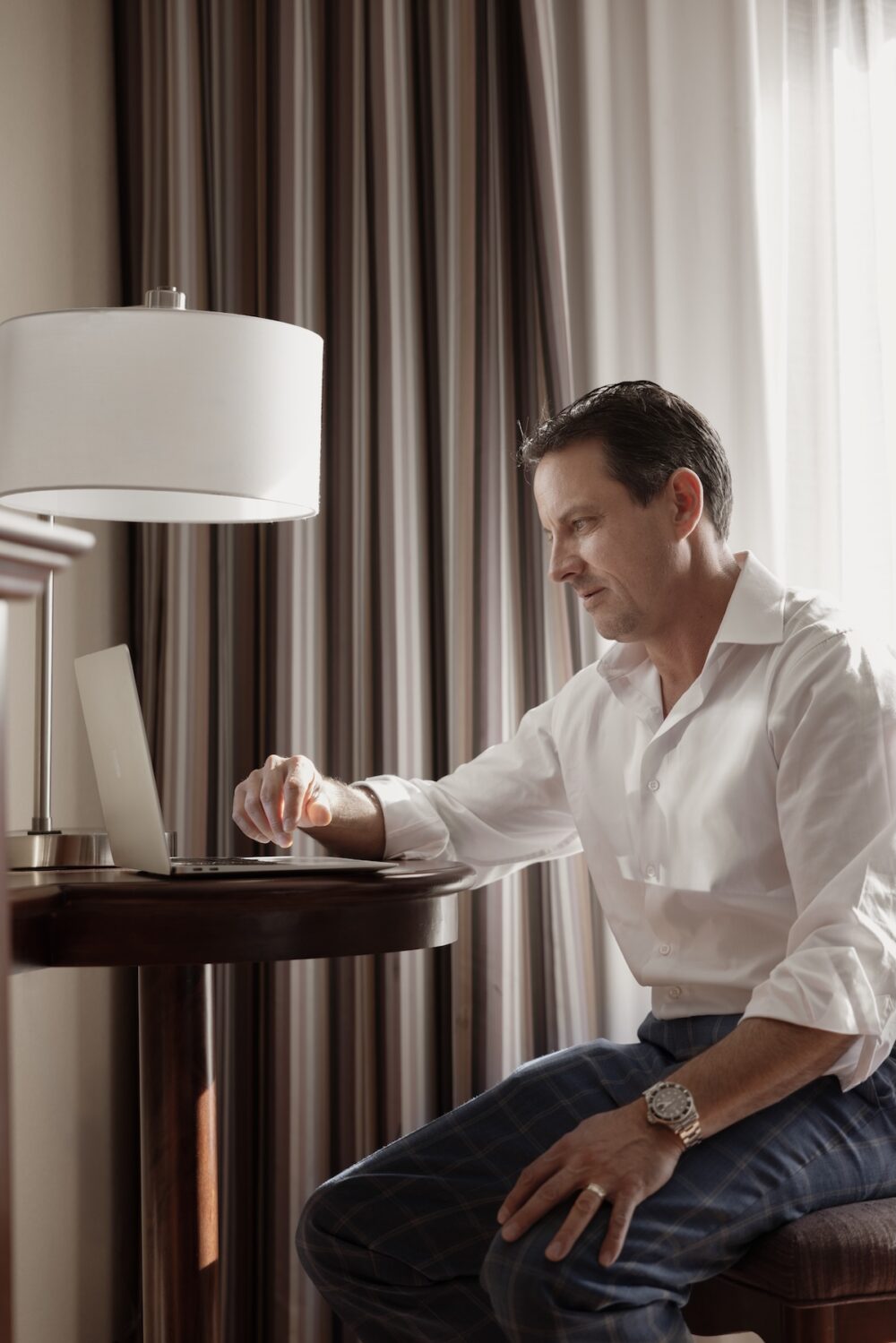 A man working at a desk in his hotel room at The Parker Hotel in Colorado.